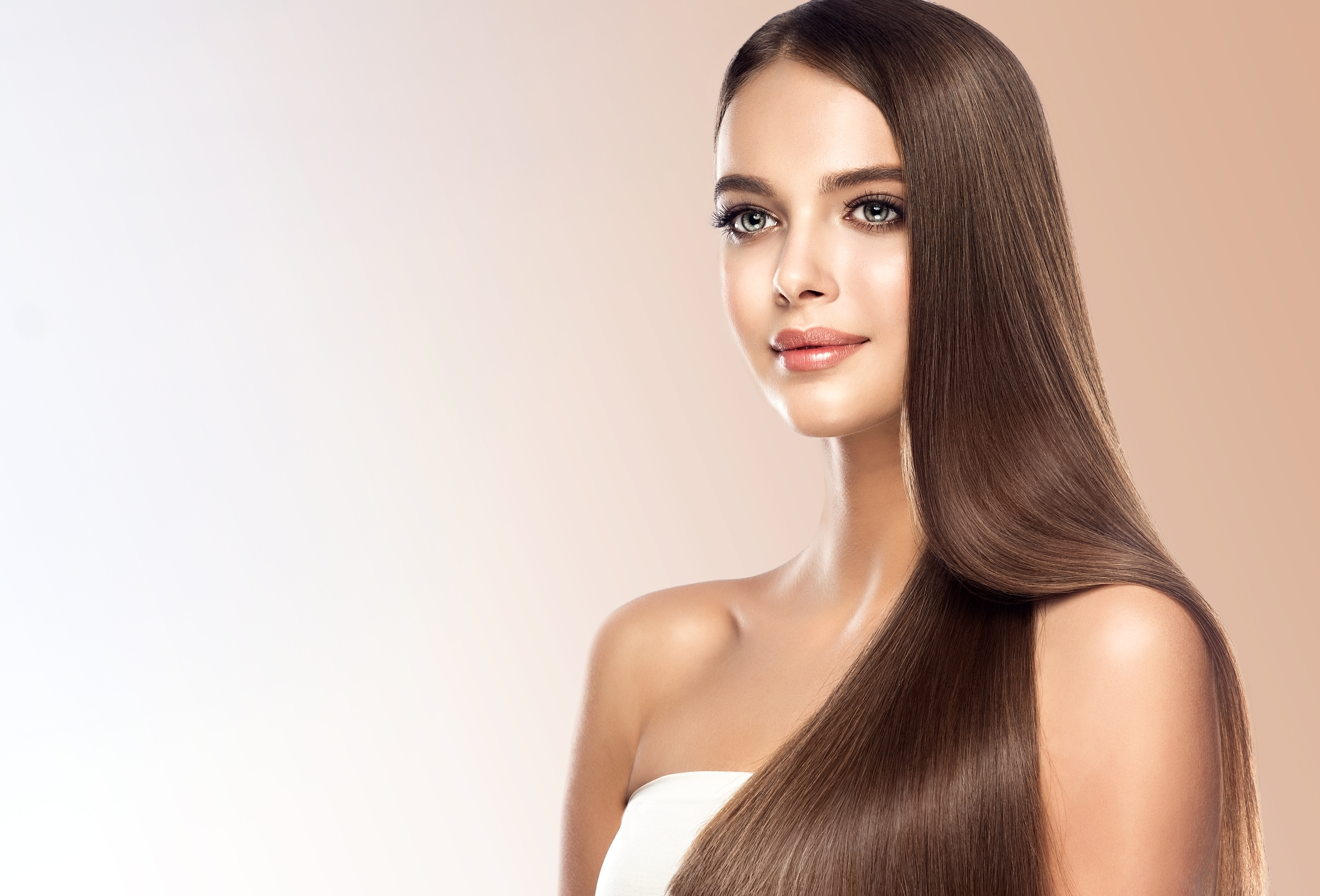 Young, brown haired beautiful model with long,  straight, well groomed hair. Hair care and hairdressing art.